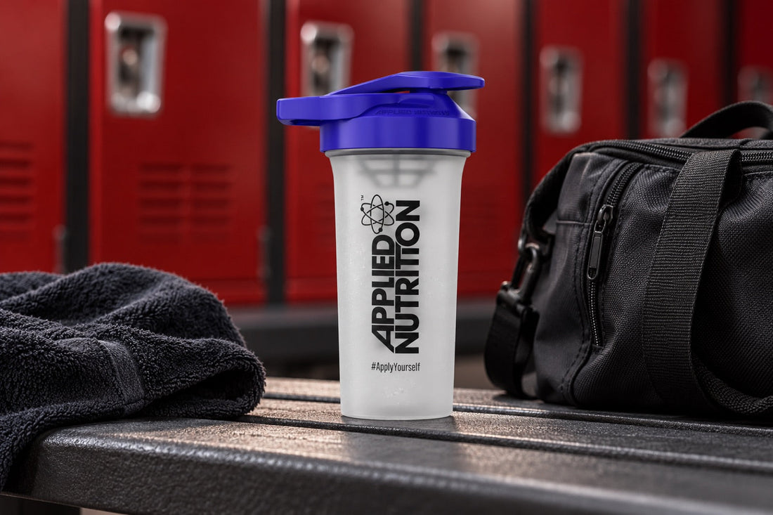 An Applied Nutrition shaker with a gym bag and towel in an illustrative locker-room setting